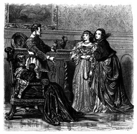 Two women and a man converse in an interior