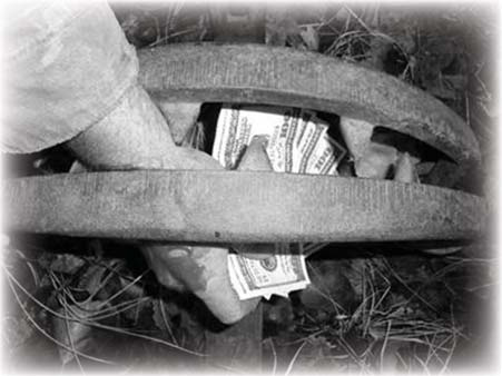A hand taking money through a wooden fence