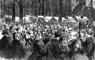 An outdoor religious gathering in a wooded camp with a preacher addressing a crowd