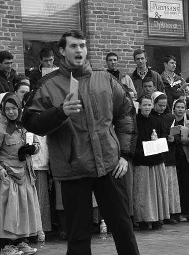 A man speaking to a crowd outdoors