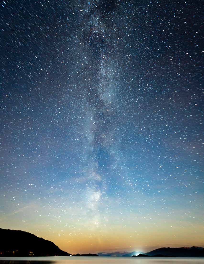 Milky Way and stars above dark mountains and water