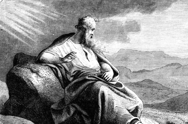 A robed, bearded man seated on a rock beneath rays of light