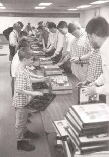 Volunteers arranging tapes into albums along a long table.