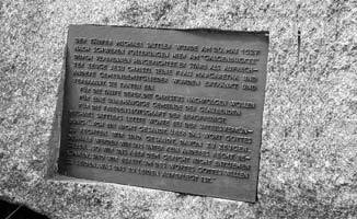 A German memorial plaque mounted on a stone