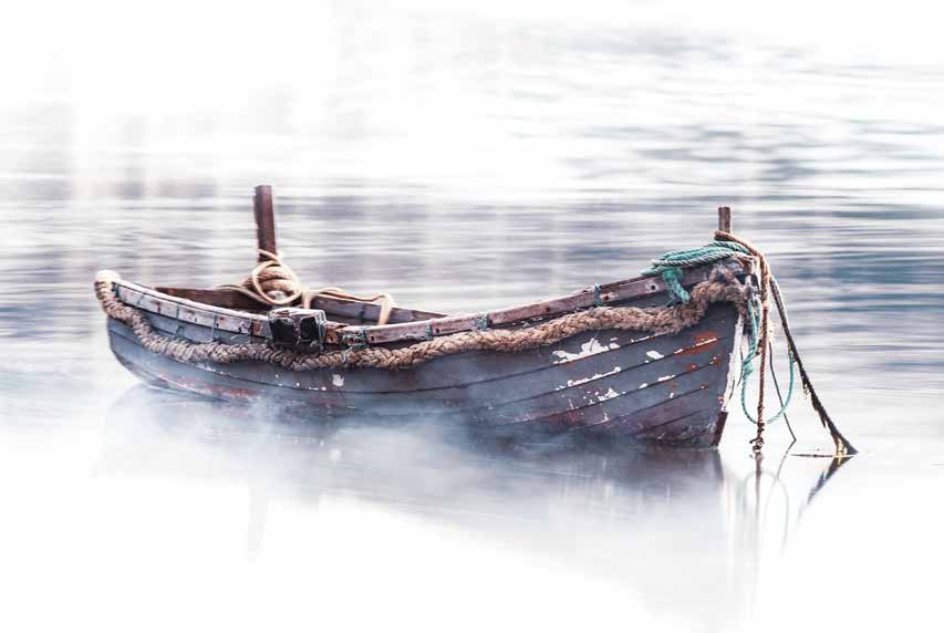 Weathered wooden fishing boat floating on calm water