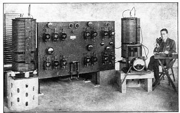 A man seated beside an early electronic machine
