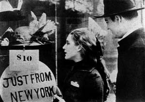 People on a city street near a sign advertising travel from New York