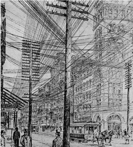 A city street filled with overhead utility wires