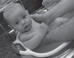 Infant held in a small bathtub