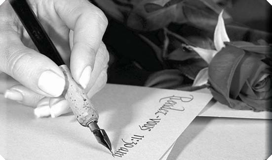A hand writing with a fountain pen beside a rose