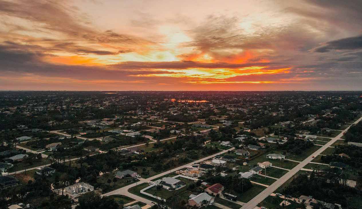 An aerial view of a town beneath an orange sunset