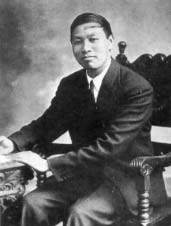 Watchman Nee seated beside a table.