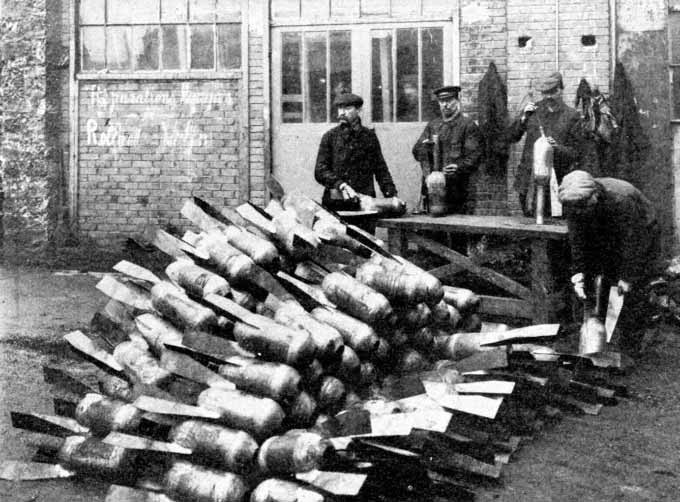 Workers beside a stack of large bombs