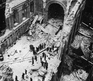 People walking through a bomb-damaged street