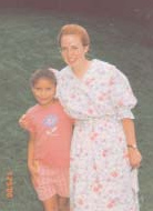 Janelle Zimmerman standing with a child outdoors.