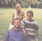 Jeremy Martin with three children outdoors.