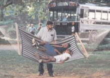 Jeff Barker standing beside a hammock with a bus in the background.