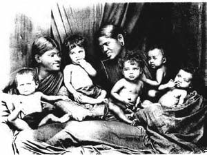 Two helpers seated with several rescued girls