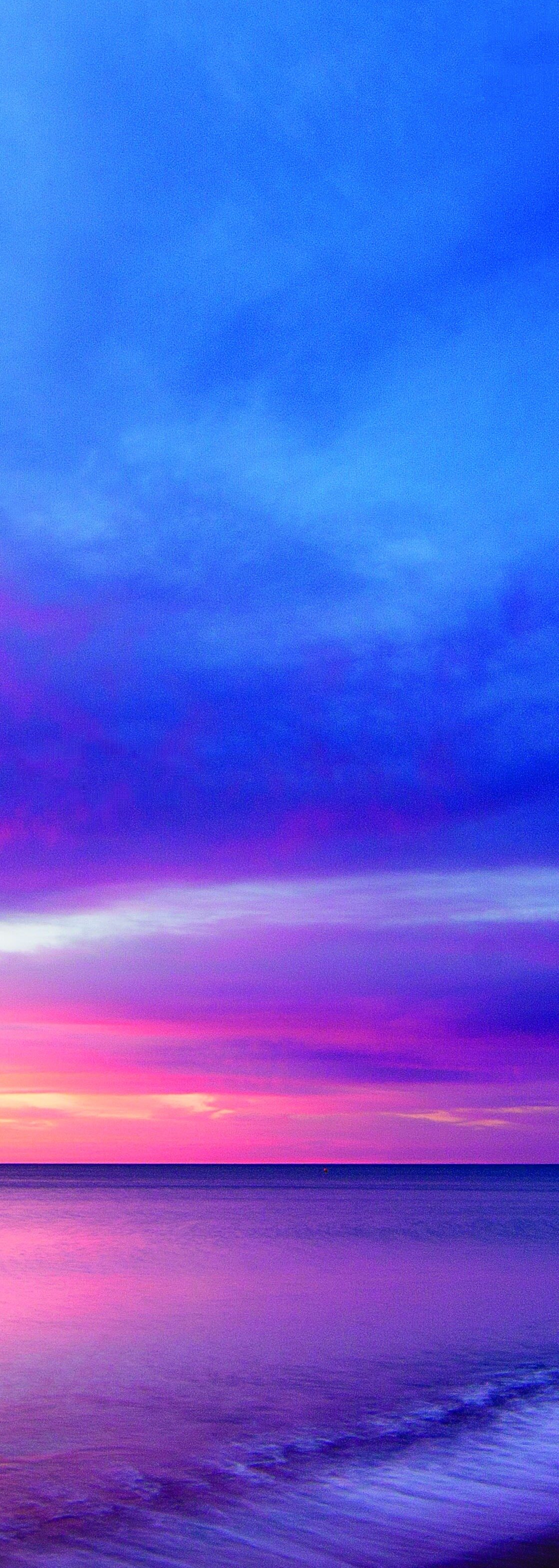 A vivid pink, purple, and blue sunset over the ocean