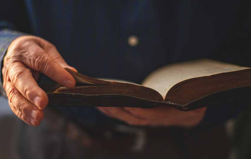A hand holding an open book