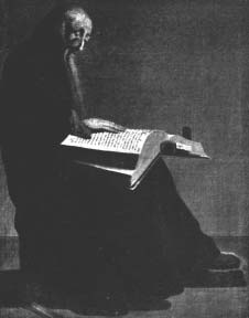 A seated person reading a large open book