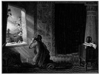 A man kneels in prayer beside an open window, with a book on a stand nearby.