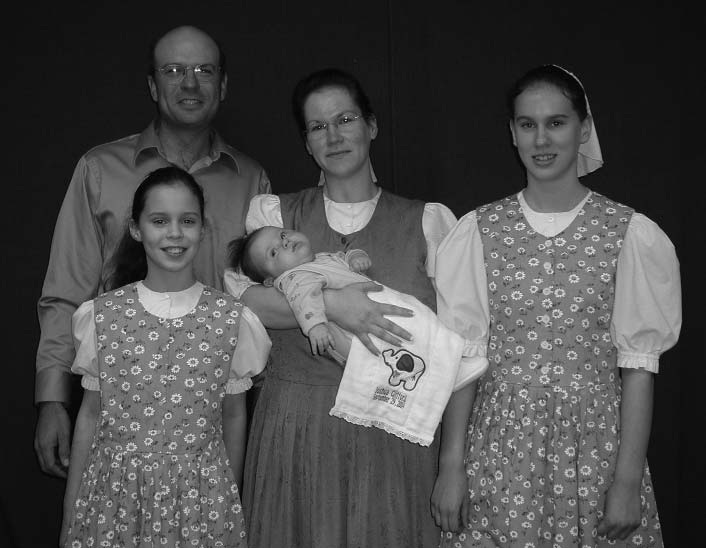 A man and woman with two girls and a baby