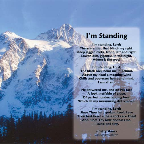 Snow-covered mountains above dark trees, with the printed poem I’m Standing.