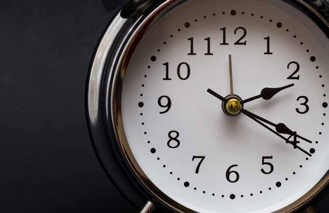 An analog clock showing a few minutes past two