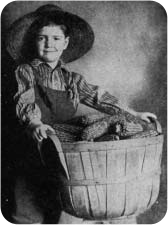 A boy in a hat beside a basket.