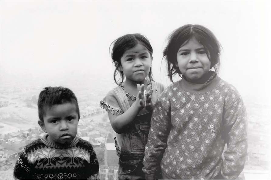 Three children standing near the river in Lima