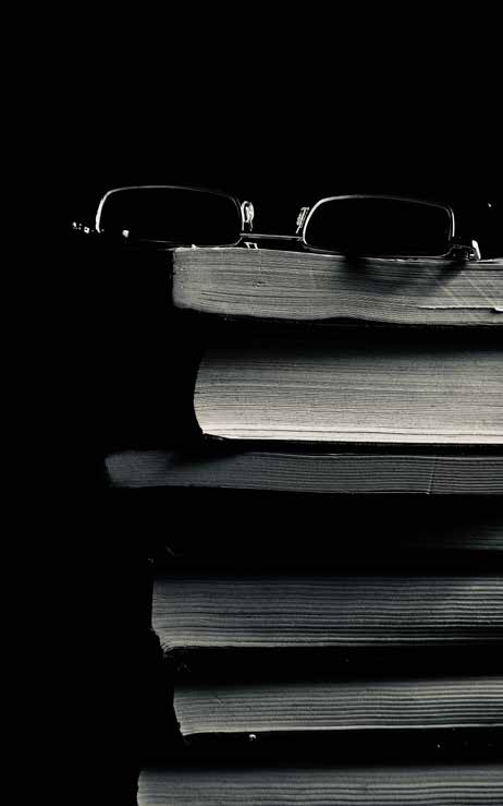 Eyeglasses resting on a stack of books