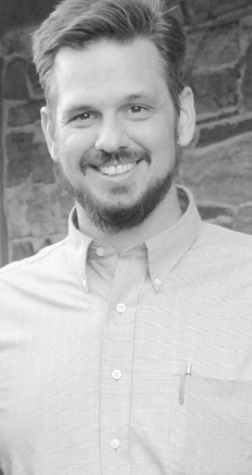 Portrait of a smiling bearded man in a light shirt