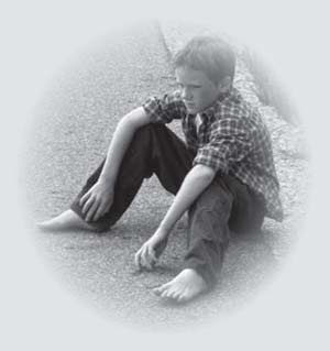 A boy seated with his knees up