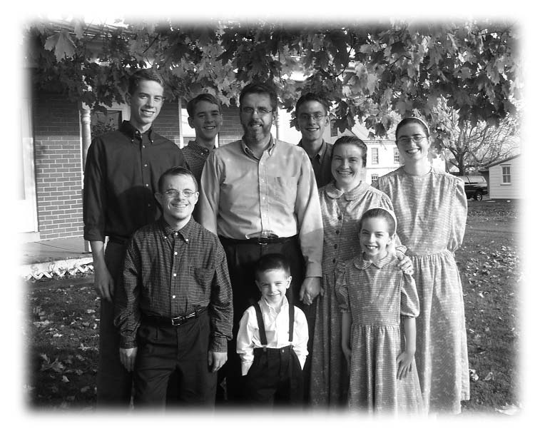 A group of adults and children posing outdoors.