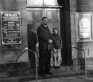 Photograph of a man and child standing outside Moriah Chapel