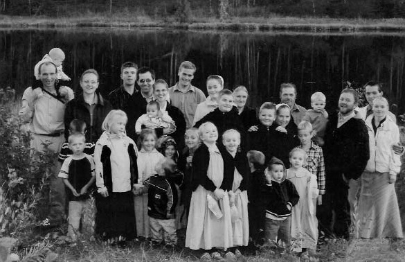 A large group of adults and children beside a lake