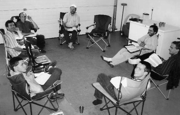Men seated in a circle with open books