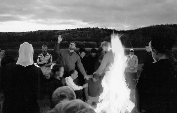 A group gathered around a fire outdoors