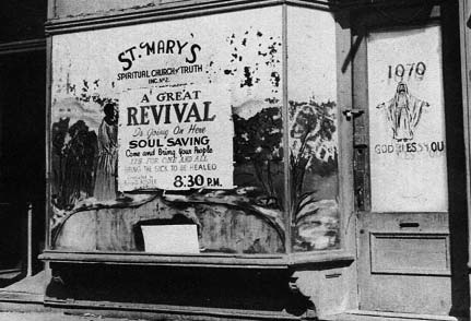 A revival notice painted on a storefront window