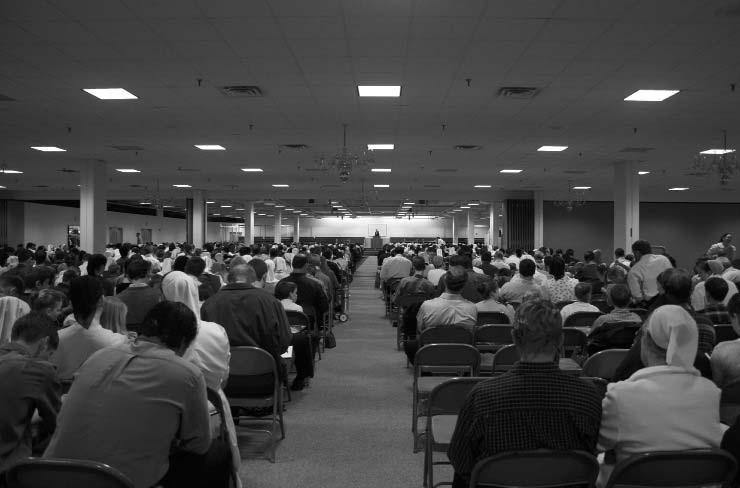 Rows of people seated in a large meeting room
