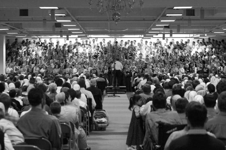 A large choir performing before a seated audience