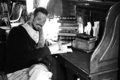 A man seated at a desk beside a window