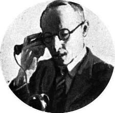 Man wearing glasses and holding a telephone receiver